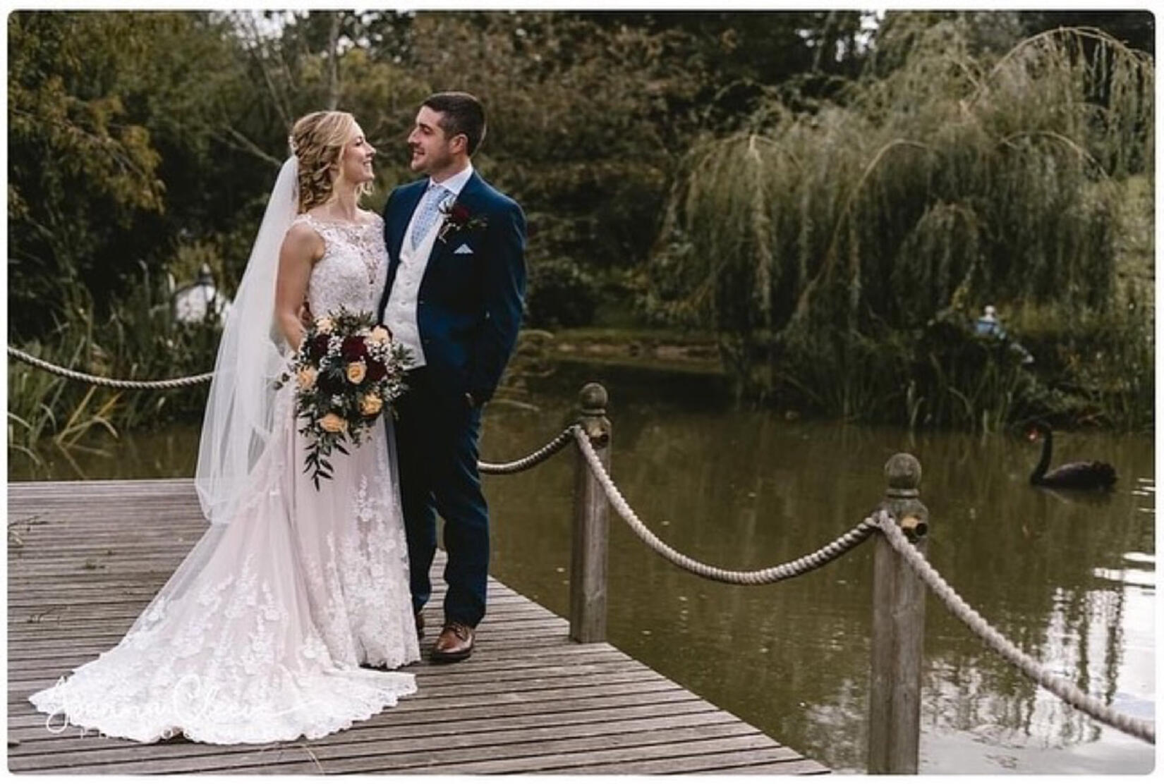 An image of the wedding couple by the pond