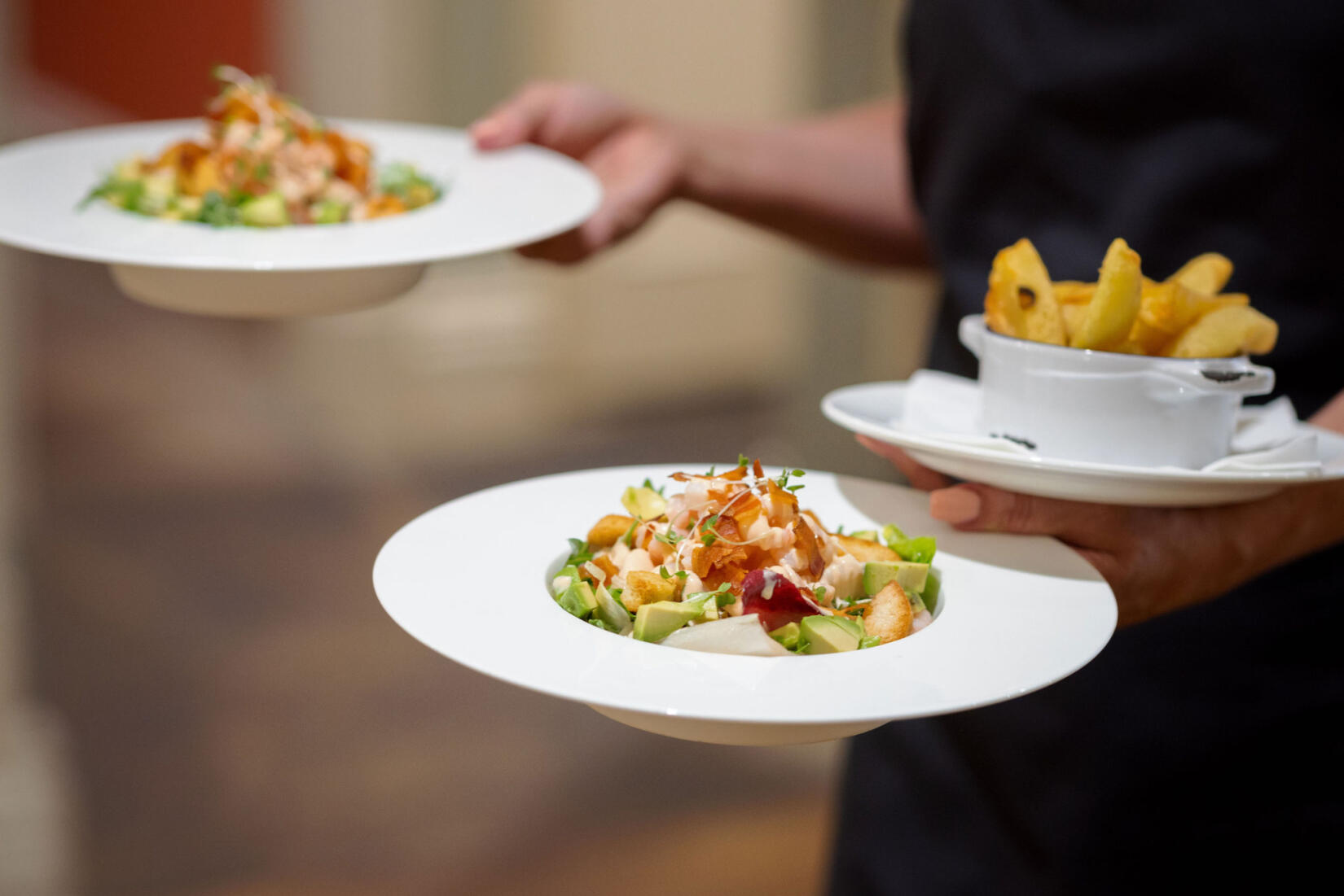 A image of a waiter bringing some of the fine dining meals